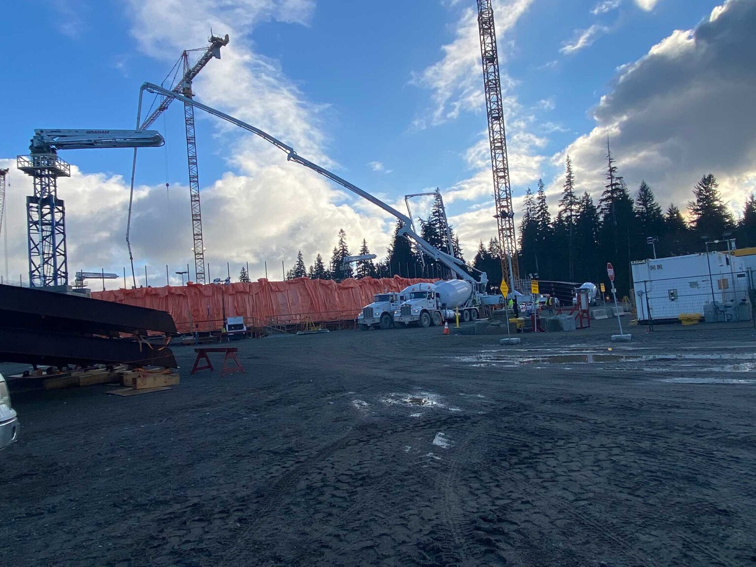 Industrial concrete pumping in action; two concrete pumping trucks, with a spider boom in use.