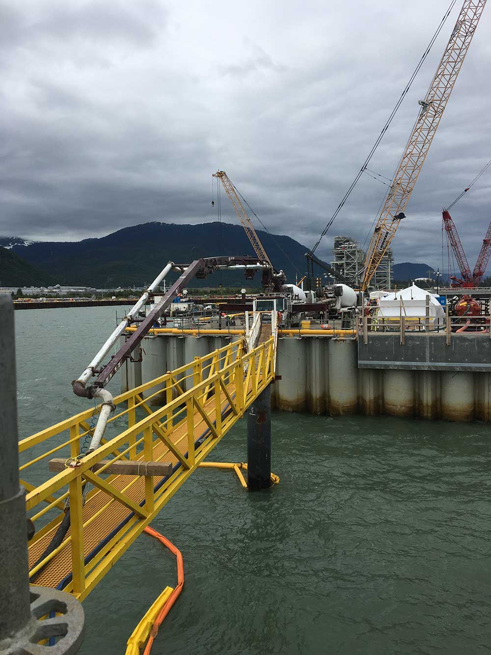 Industrial concrete pumping on a barge in the middle of the water.