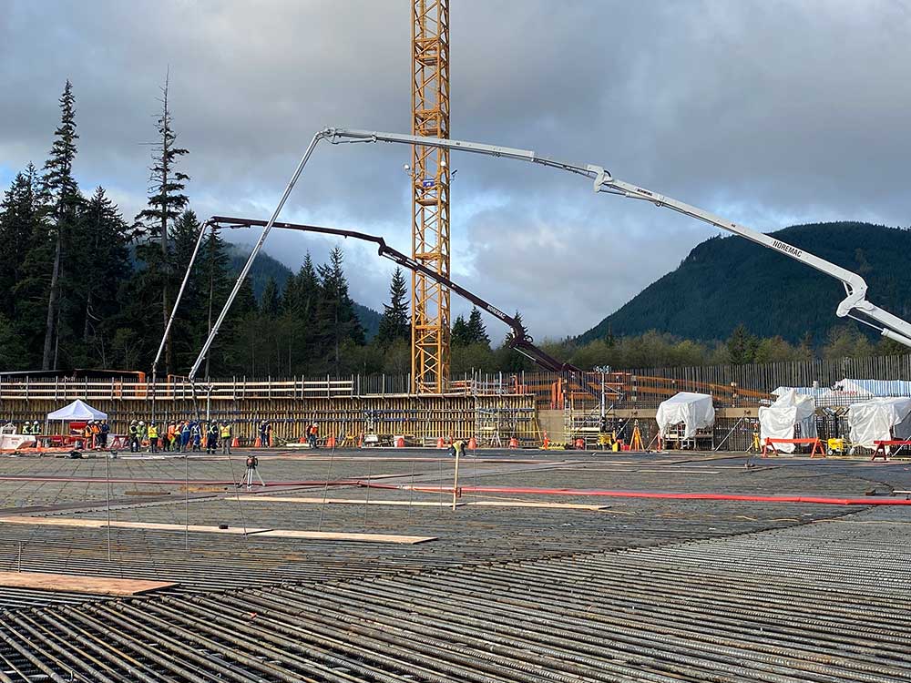 Industrial concrete pumping with Noremac-branded placing booms in action.