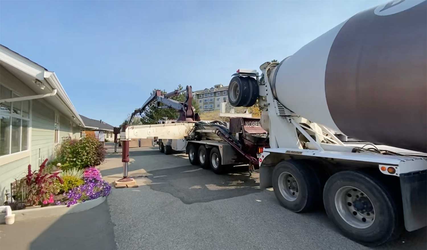 Residential concrete pumping. A Noremac-branded concrete mixer with a concrete pumping setup.
