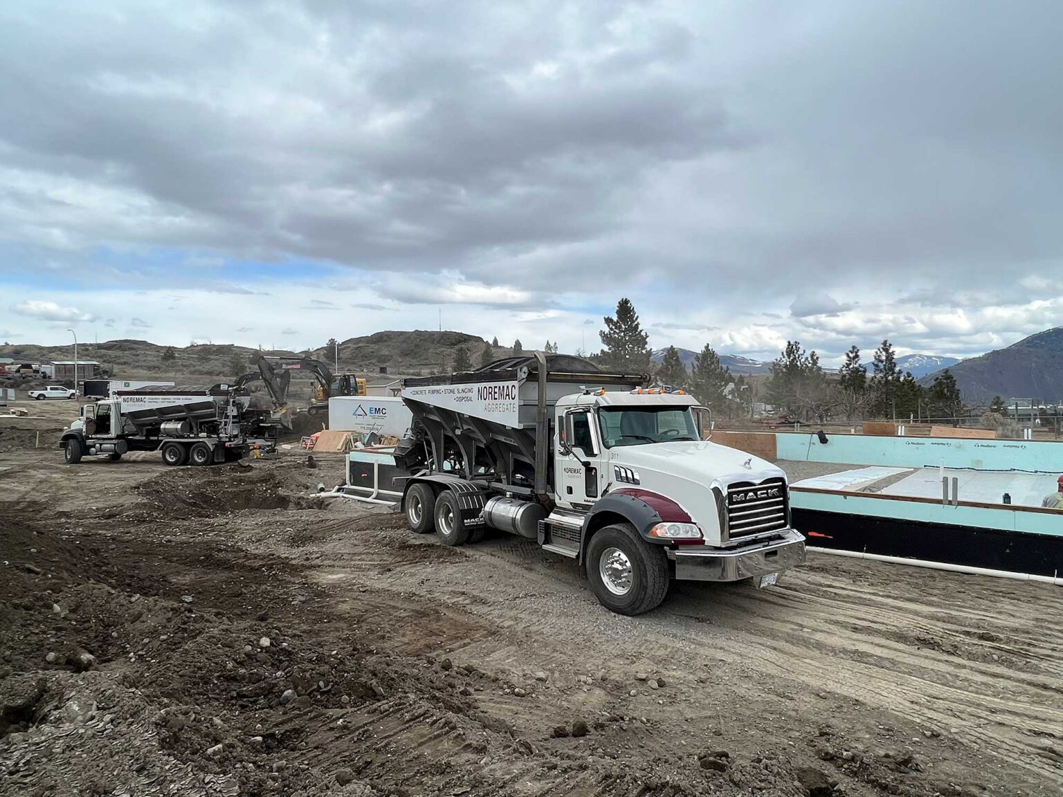 A stone slinger on a job site with the words Noremac Aggregate written on it.
