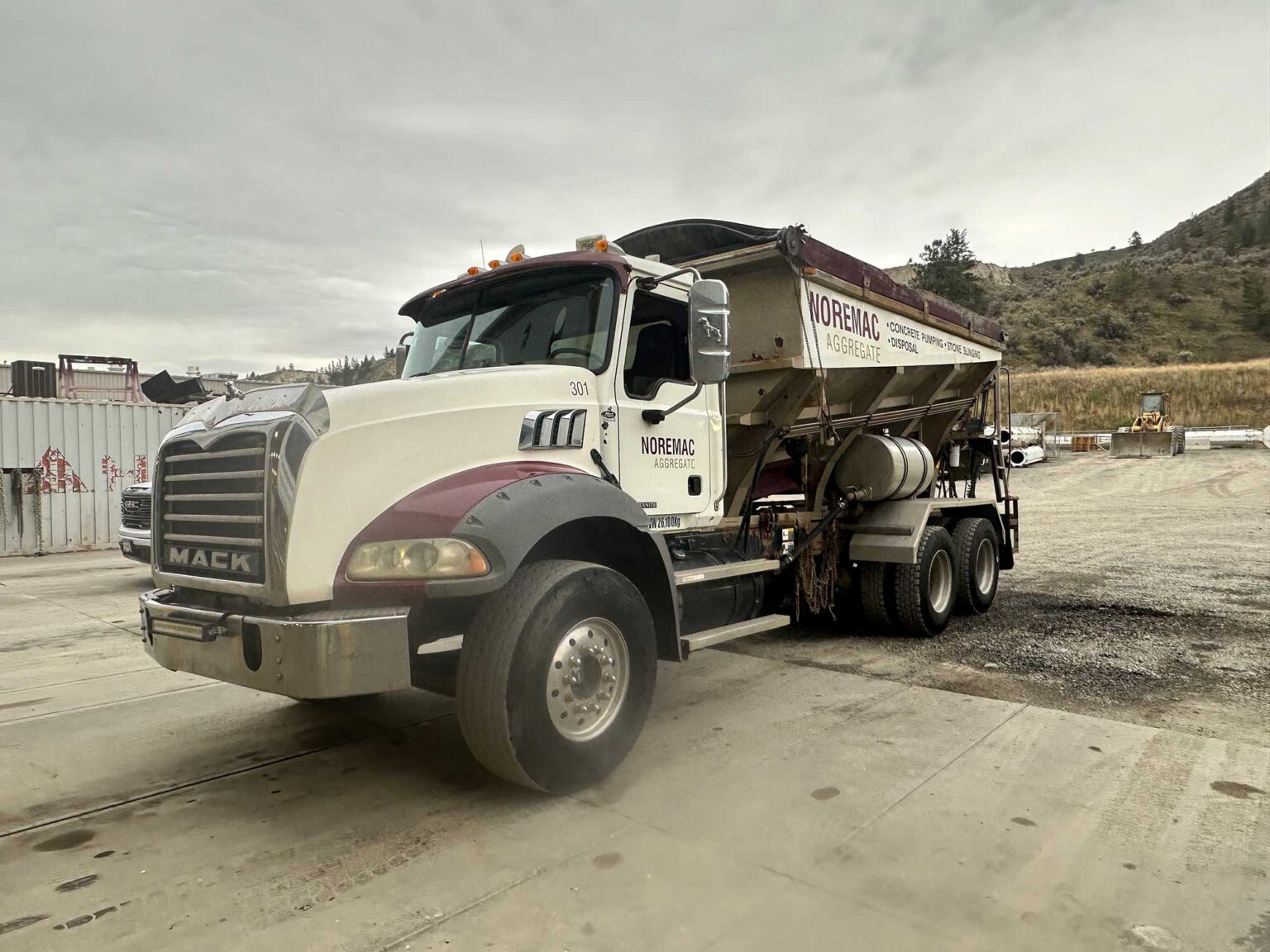 A stone slinger MACK truck with Noremac Aggregate written across the side.