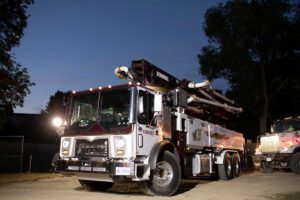 Noremac branded concerete pumping equipment in use at dusk.