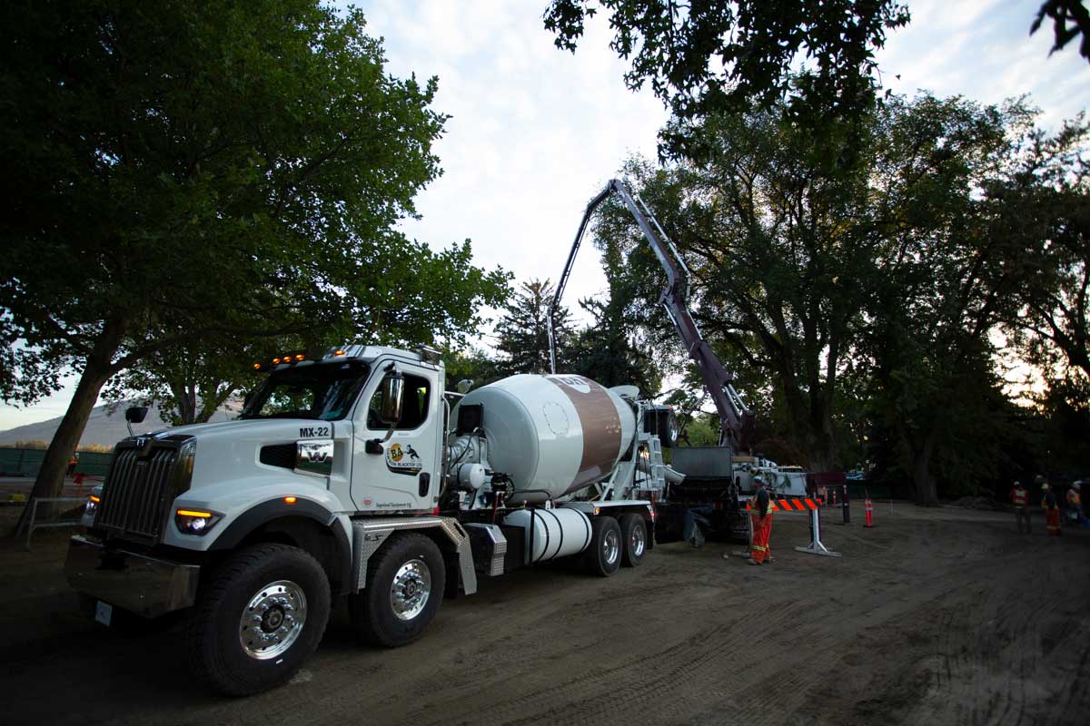 A Noremac concrete mixer in the evening, a spider boom in the background.