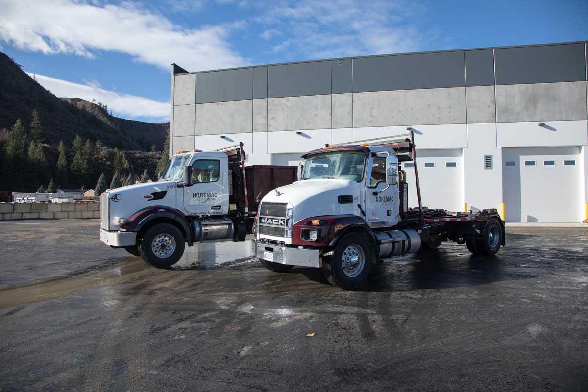 Two Noremac roll-off bin trucks are ready for action.
